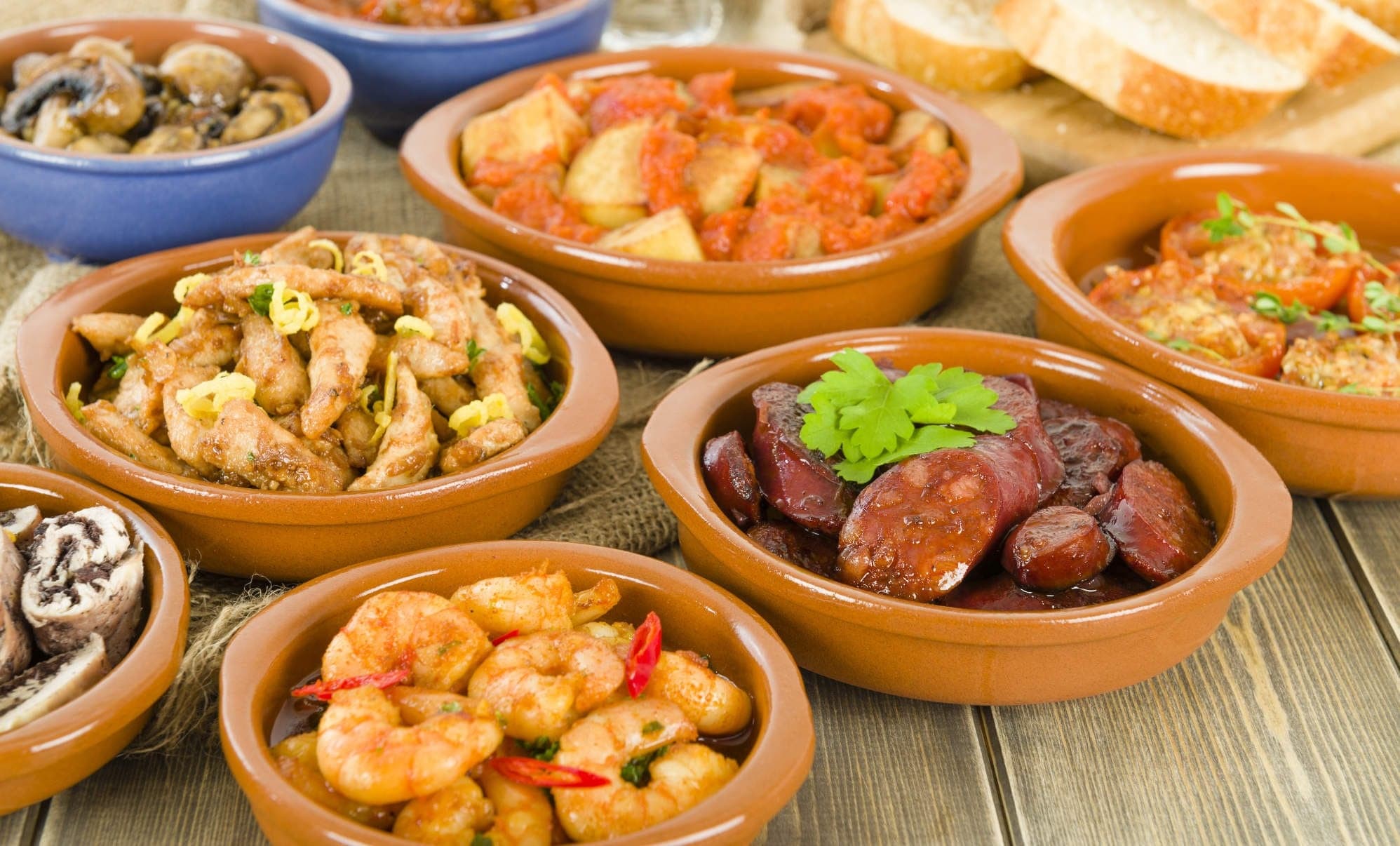 Assorted Spanish tapas dishes in terracotta bowls, Andalusia food tour