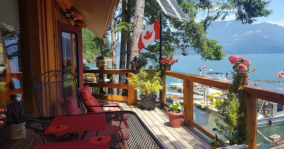 Lakeside deck seating overlooking mountains and calm water