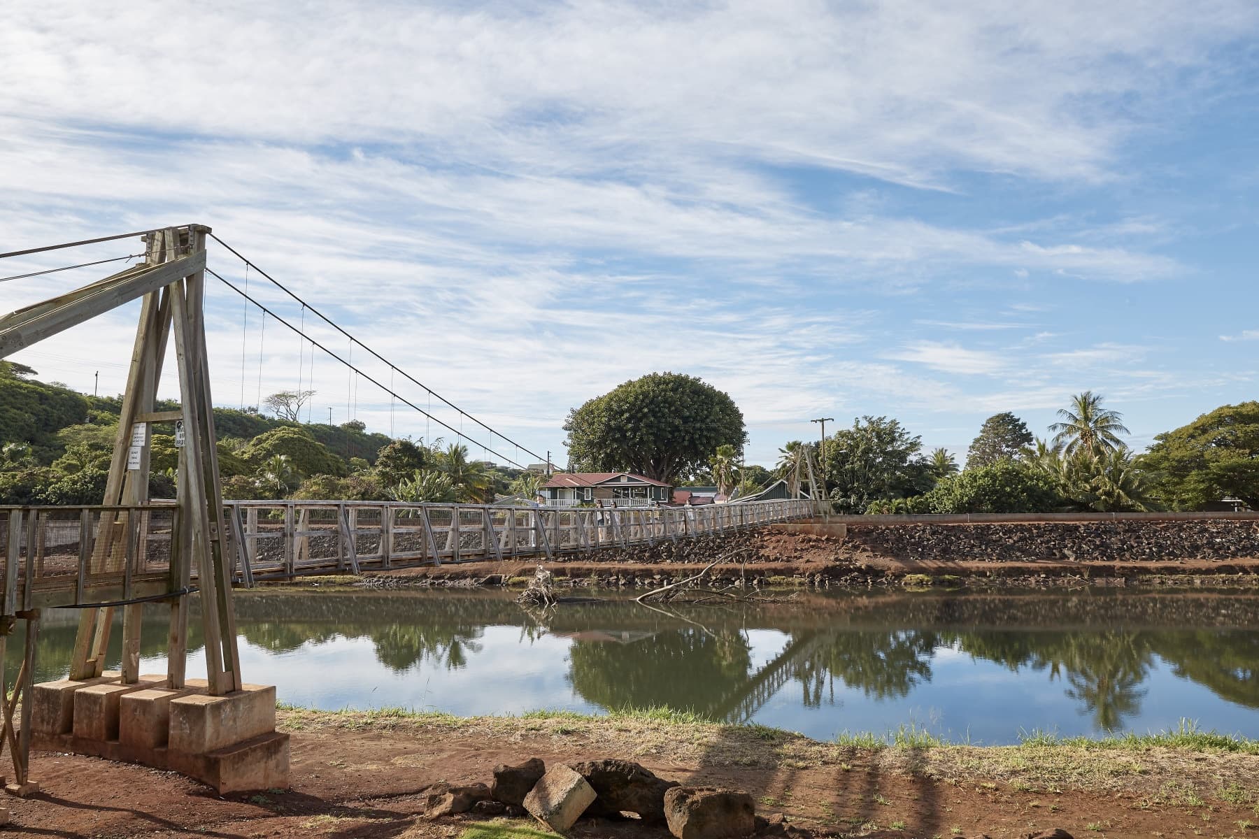 Wooden suspension bridge over reflective lagoon for nature walks
