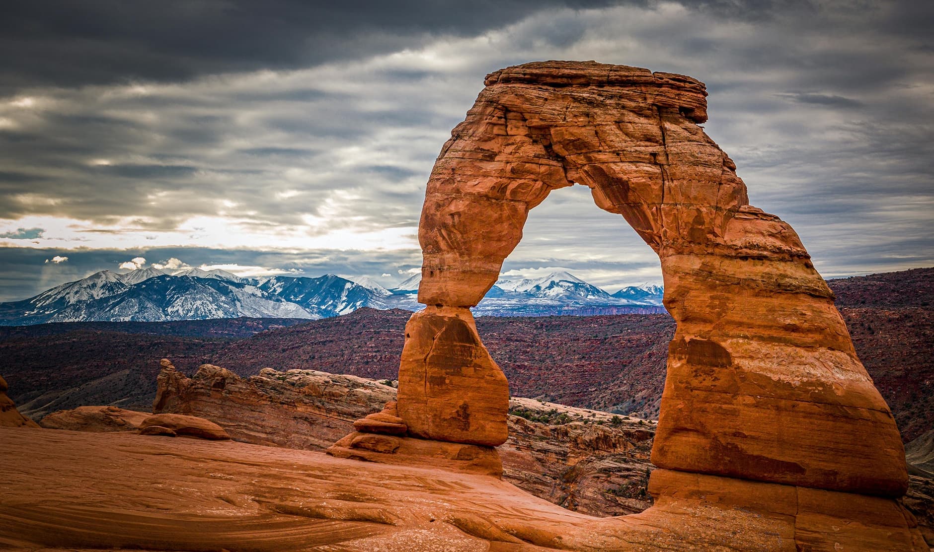 Hikers viewing Delicate Arch sandstone formation at Arches NP