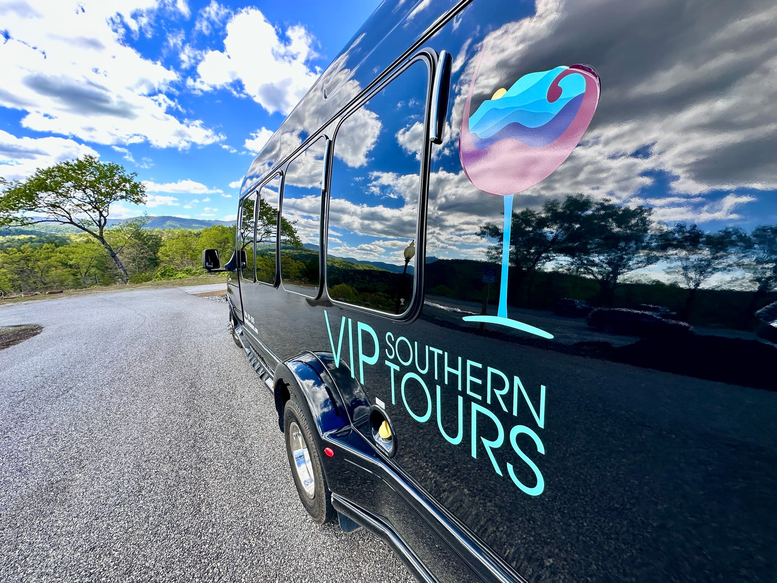VIP tour van parked on scenic roadside reflecting countryside views