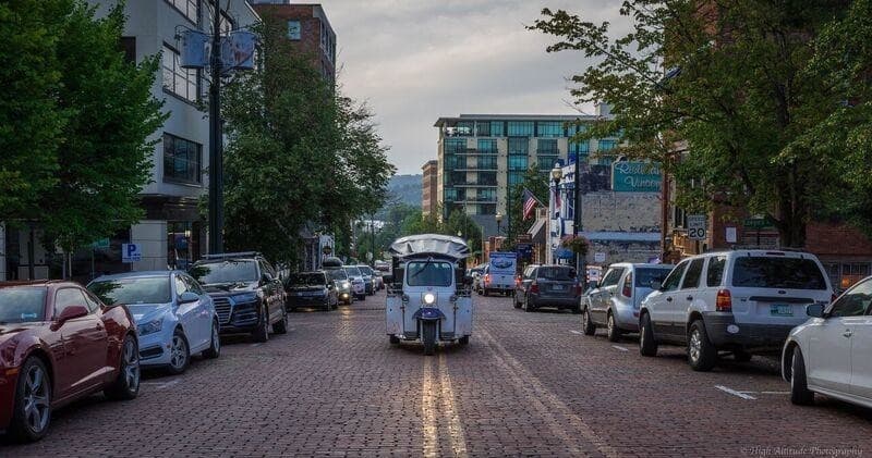 Cobblestone downtown street with vintage car driving through