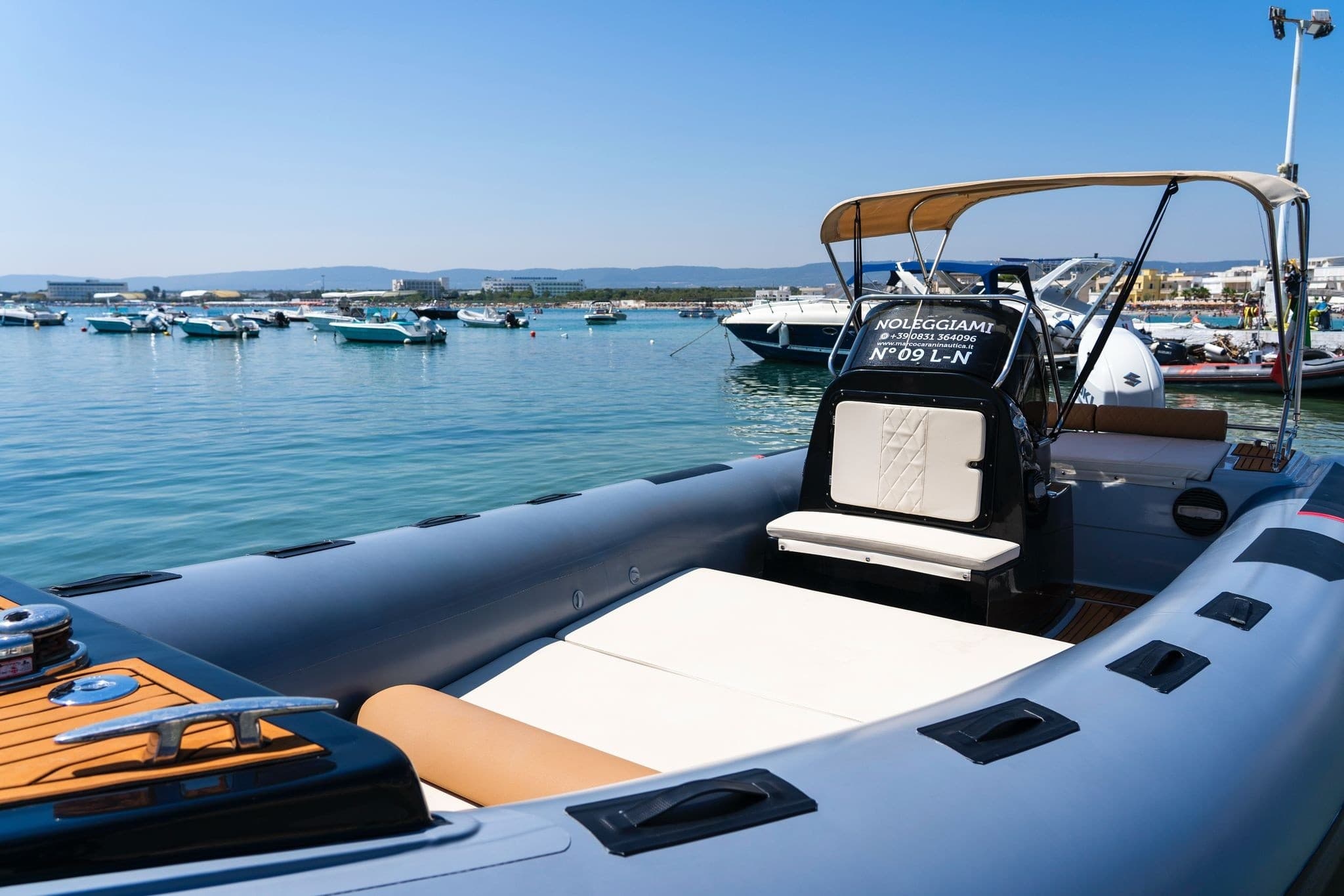 Luxury RIB boat deck moored in sunny harbor for sea trips