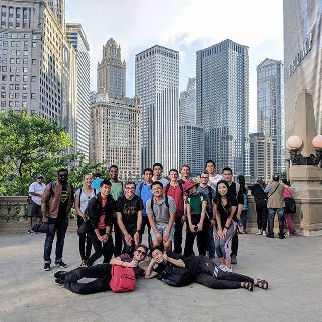 Large group walking tour posed with Chicago skyline riverwalk