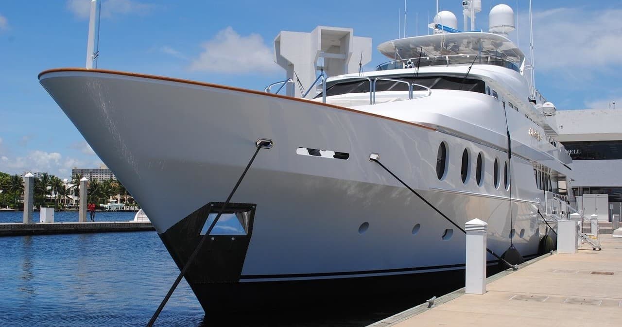 Luxury motor yacht docked at marina under clear blue sky