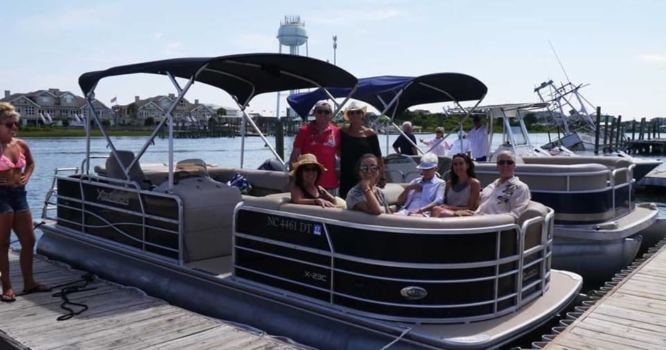 Group aboard pontoon boat at marina enjoying a summer cruise