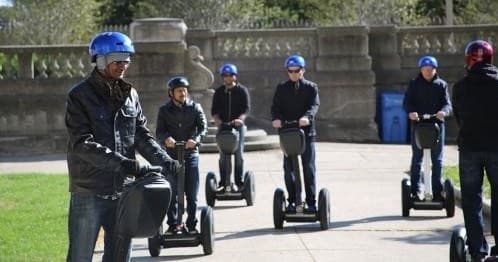 Segway riders touring Chicago park with helmets and scooters