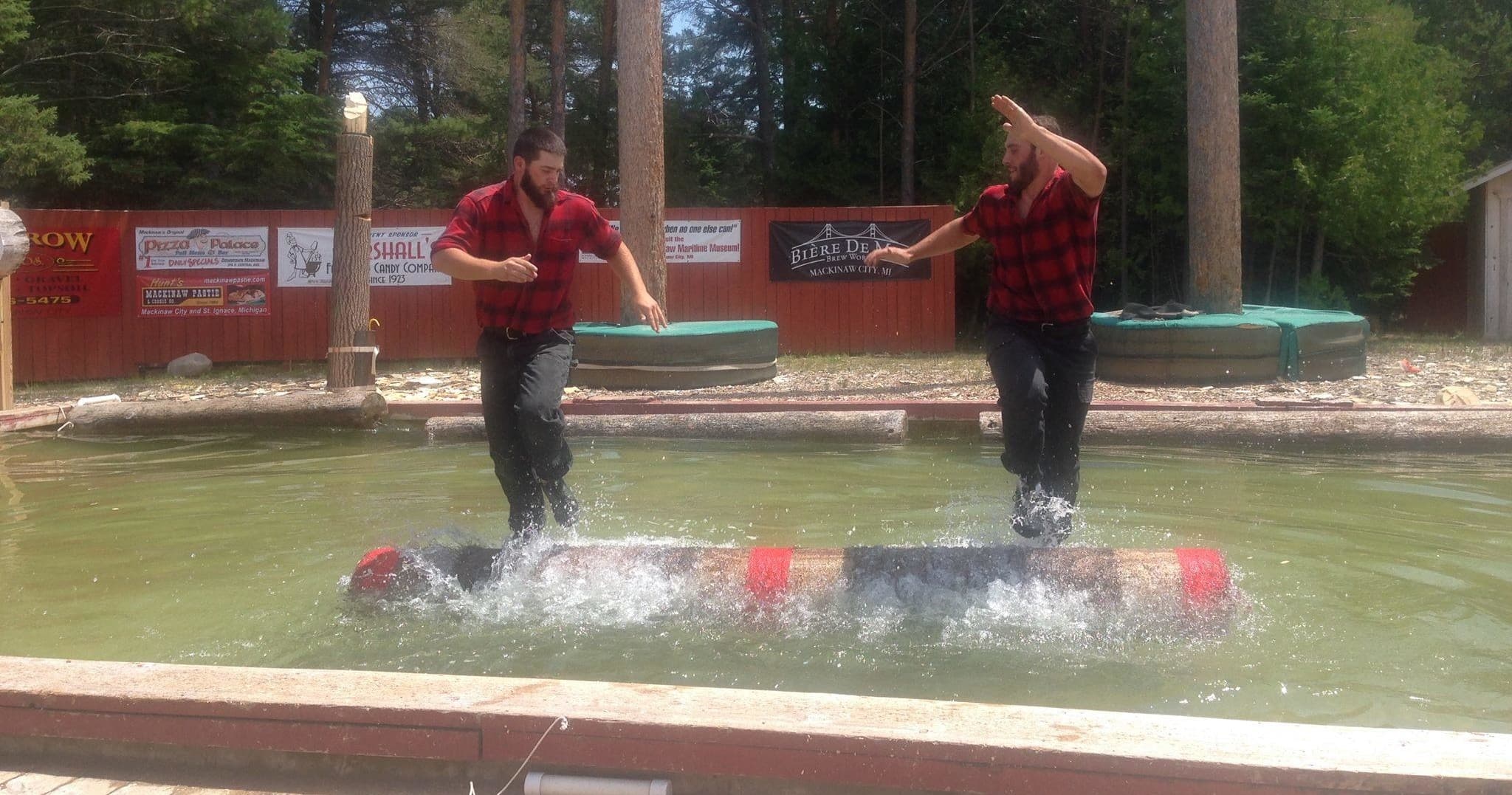 Two lumberjacks log-rolling on a pond at outdoor timber show