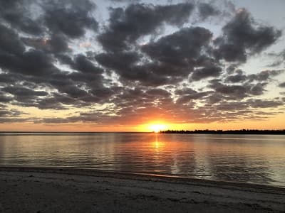 Sunset over tranquil beach with colorful skyline and water