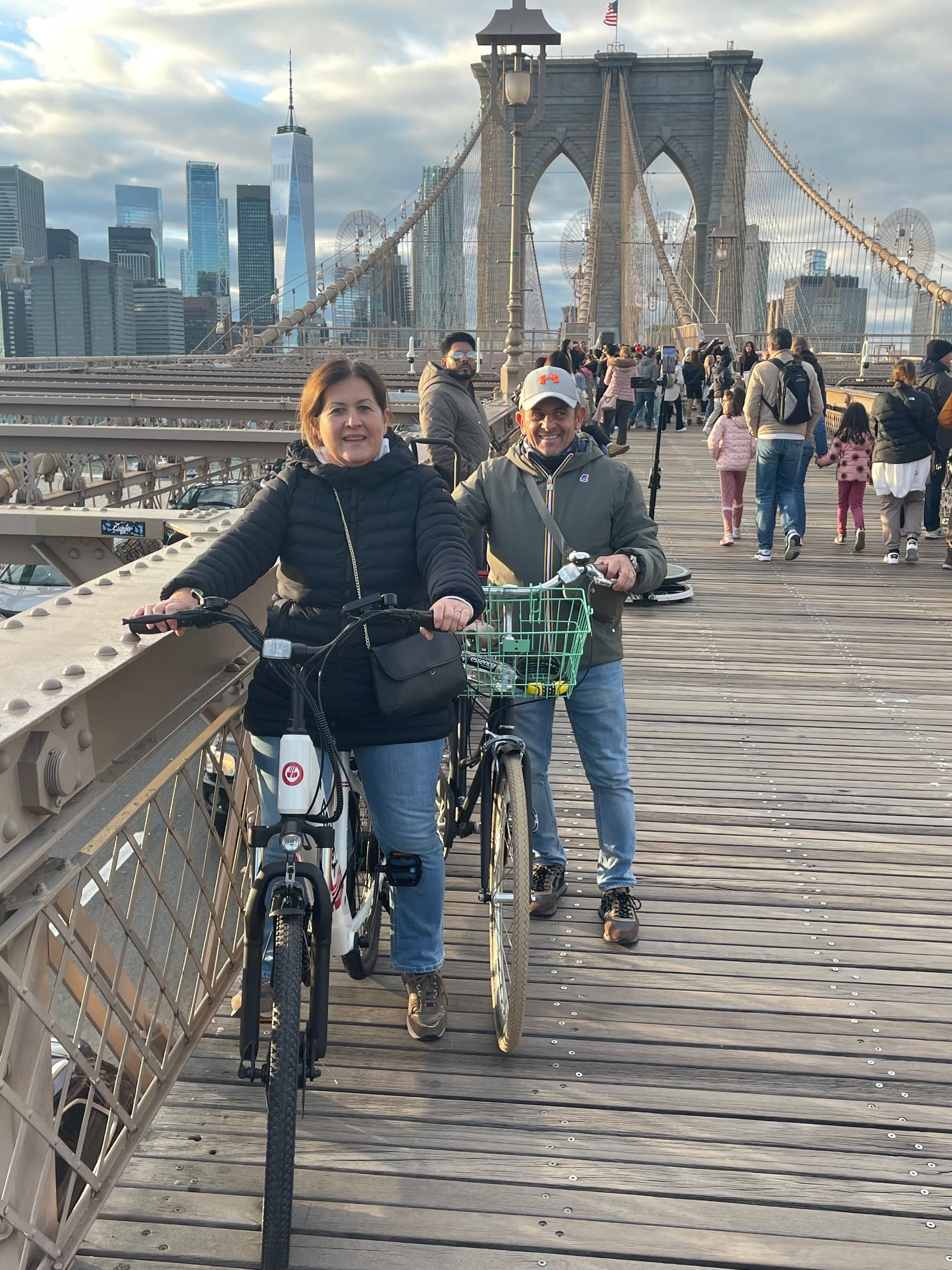 Cyclists riding across Brooklyn Bridge with Manhattan skyline