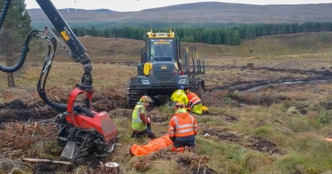 Field rescue training on moorland next to harvester, casualty evacuation