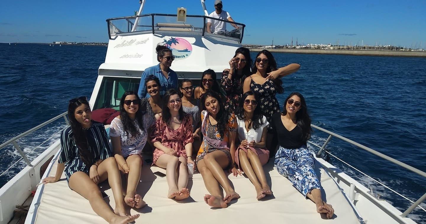 Friends relaxing on motorboat bow during sunny ocean cruise