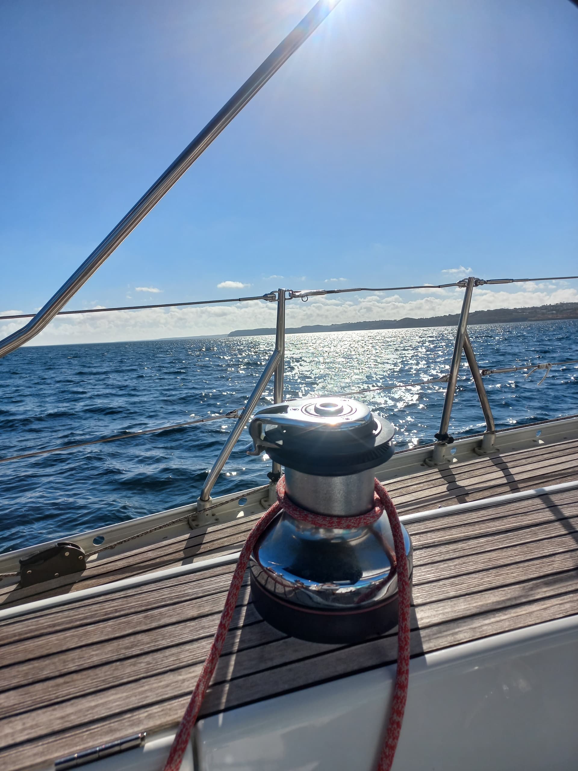 Close-up winch and rope on sailboat deck with ocean view
