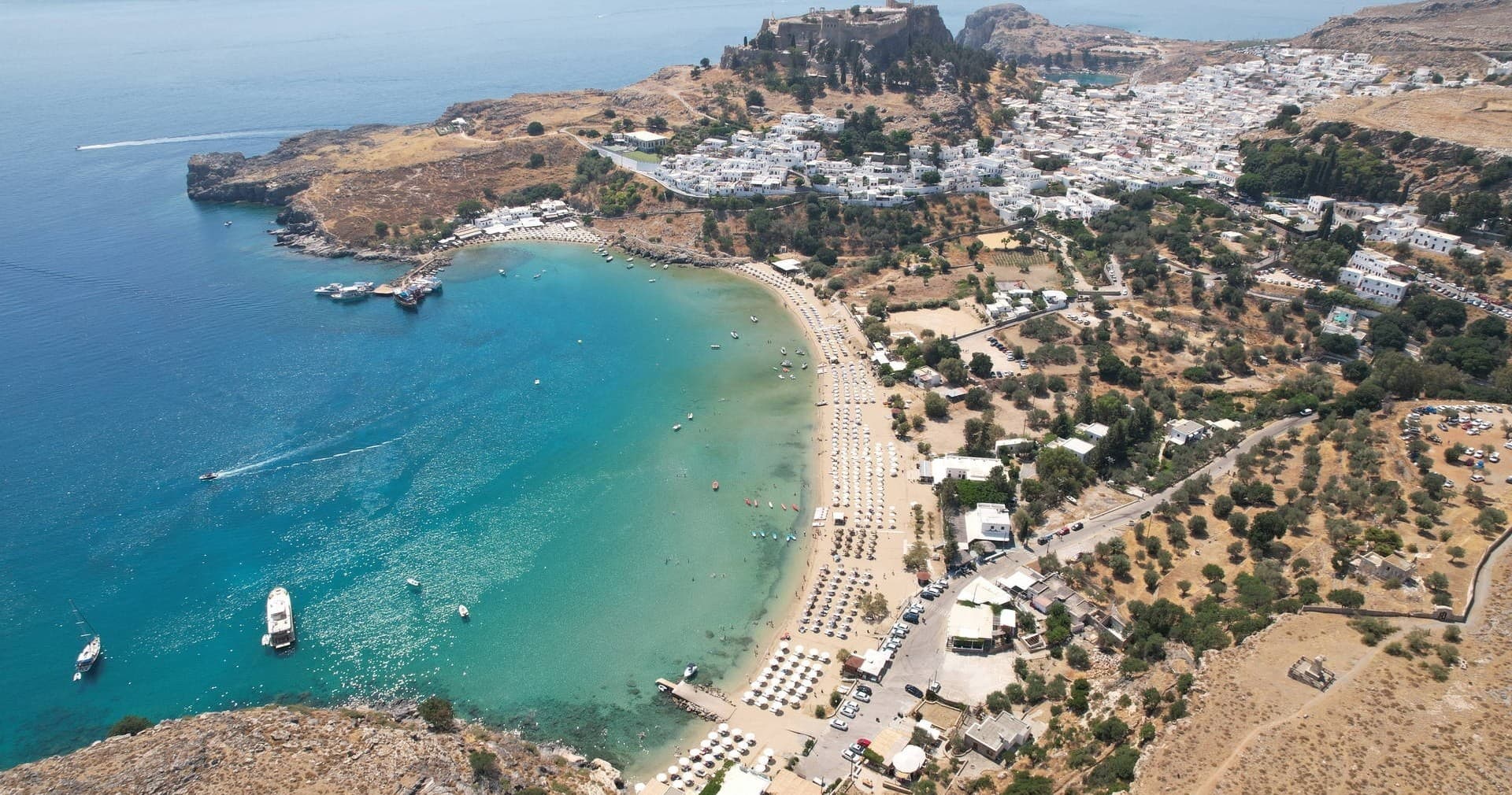 Aerial beach view of sandy bay and boats on Rhodes coast