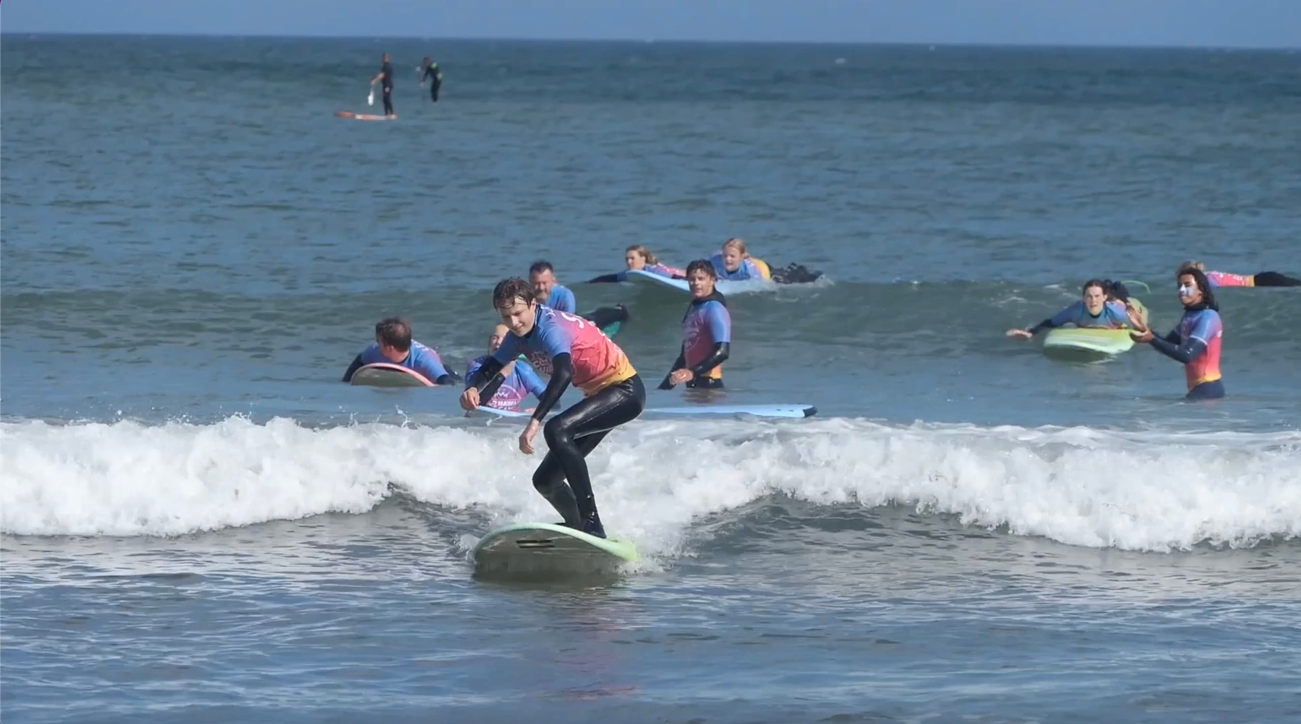 Multiple surfers catching small waves during ocean surf session