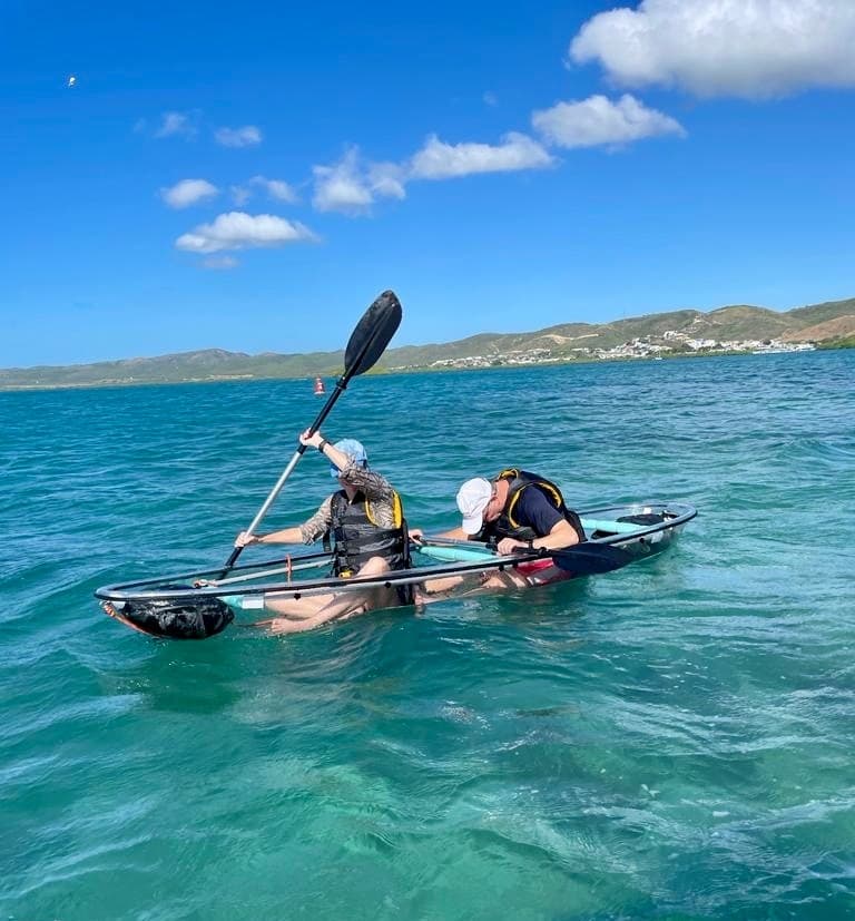 Two kayakers paddling in clear tropical turquoise sea