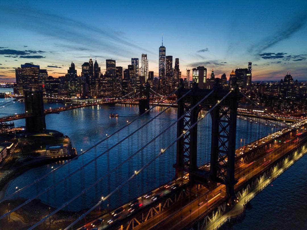 Night skyline with Brooklyn Bridge, scenic urban bike tour view