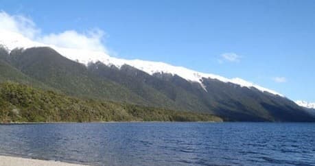 Scenic mountain range along coastal fjord with calm waters