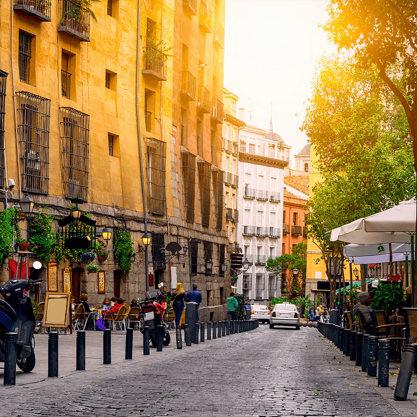 Cobblestone Madrid street with outdoor cafes and al fresco diners