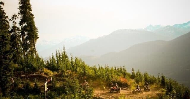 Scenic mountain valley with cabins and hiking trails, wilderness vista