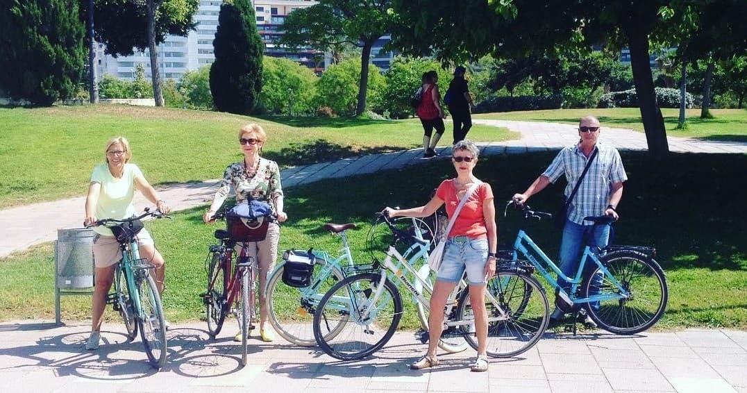 Family bike tour cycling through green urban park on trail
