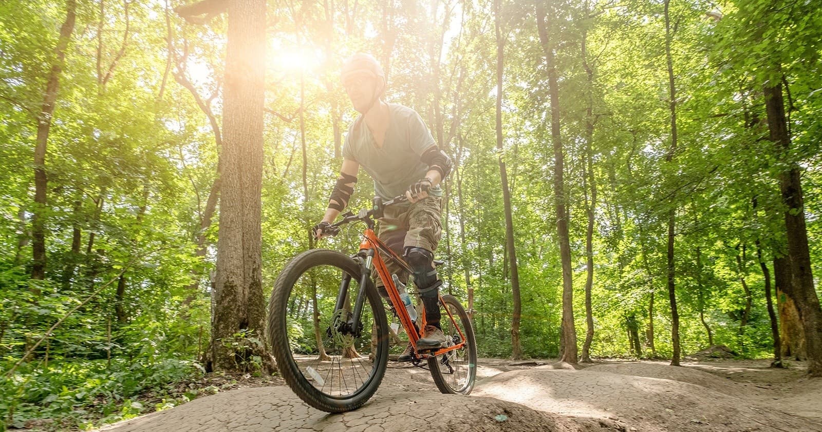 Mountain biker enjoying sunlit forest singletrack trail ride