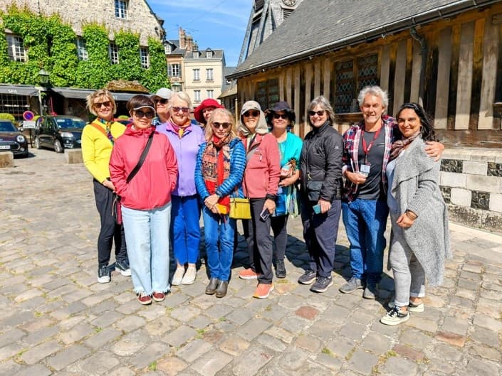 Guided walking tour group posing in Honfleur historic market square
