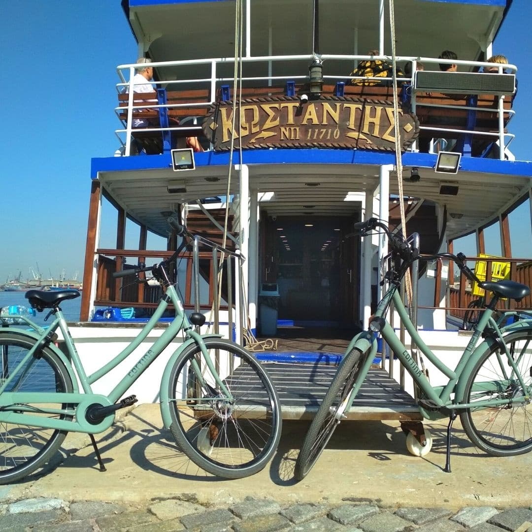 Docked tour boat with bicycles on quay under clear sky