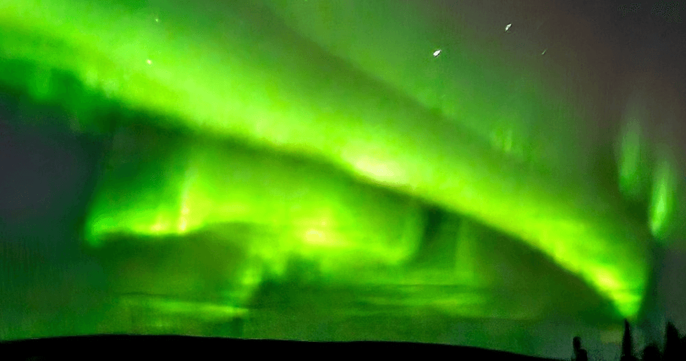 Vibrant northern lights aurora over Alaska tundra at night