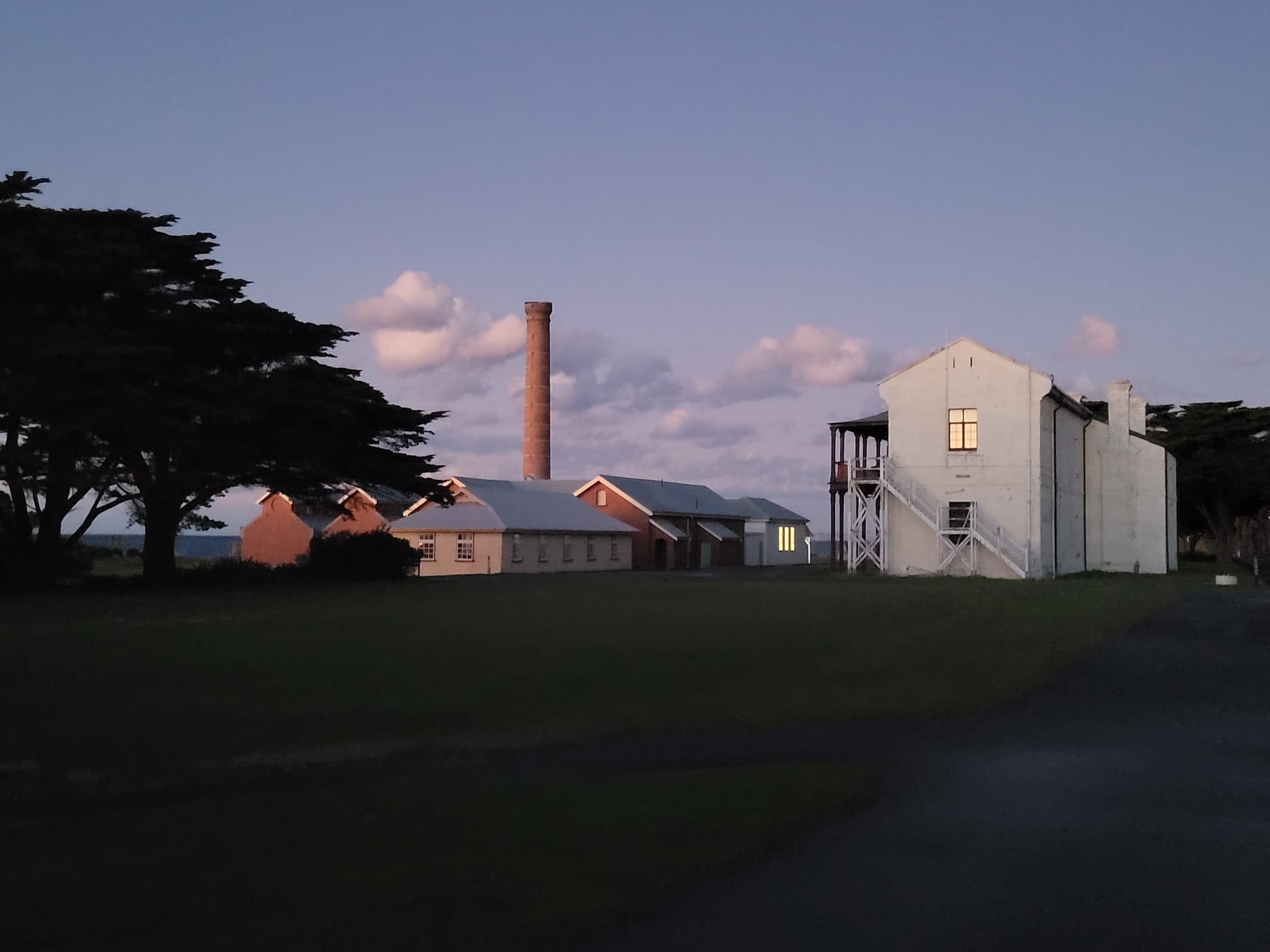 Historic coastal fort buildings at dusk on grassy field