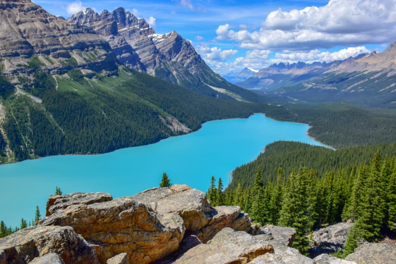 Overlook view of turquoise valley lake and distant mountains
