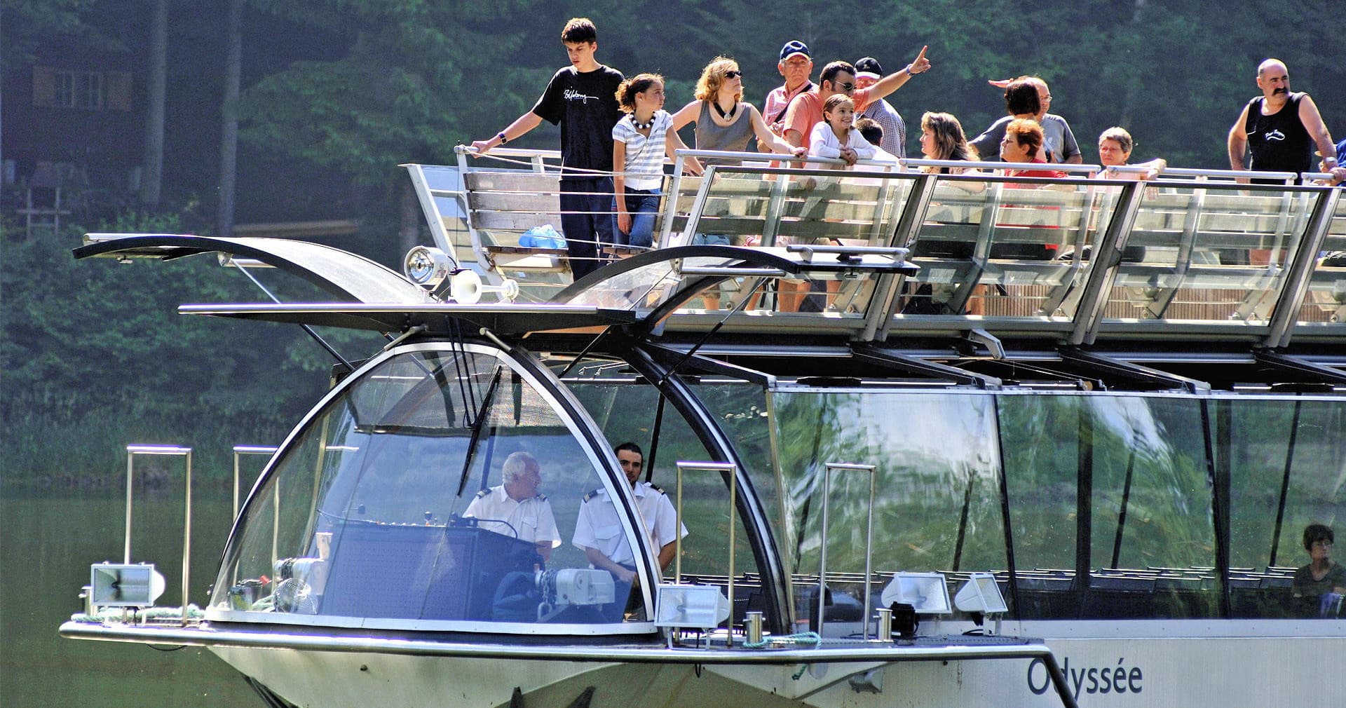 Upper-deck river tour boat with tourists enjoying views