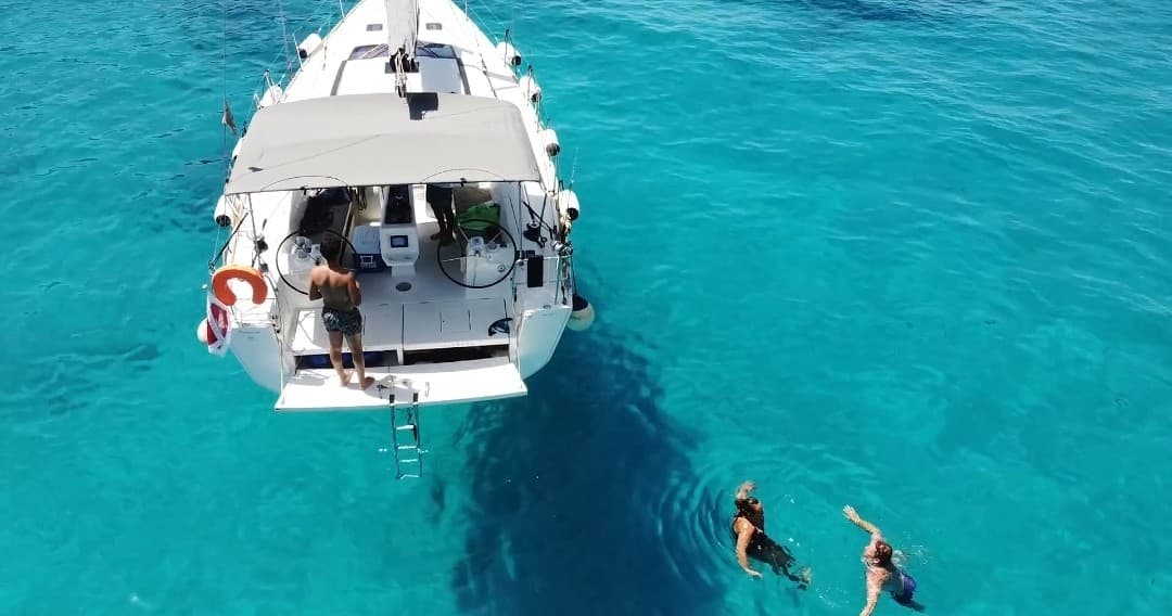 Guests jumping from yacht into crystal clear Mediterranean water off Malta