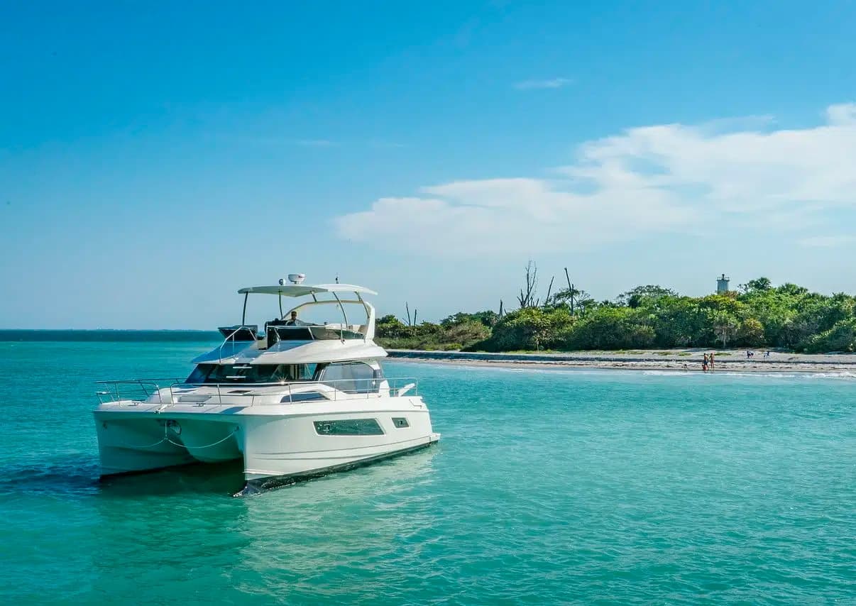 Catamaran cruising turquoise waters near tropical island shore
