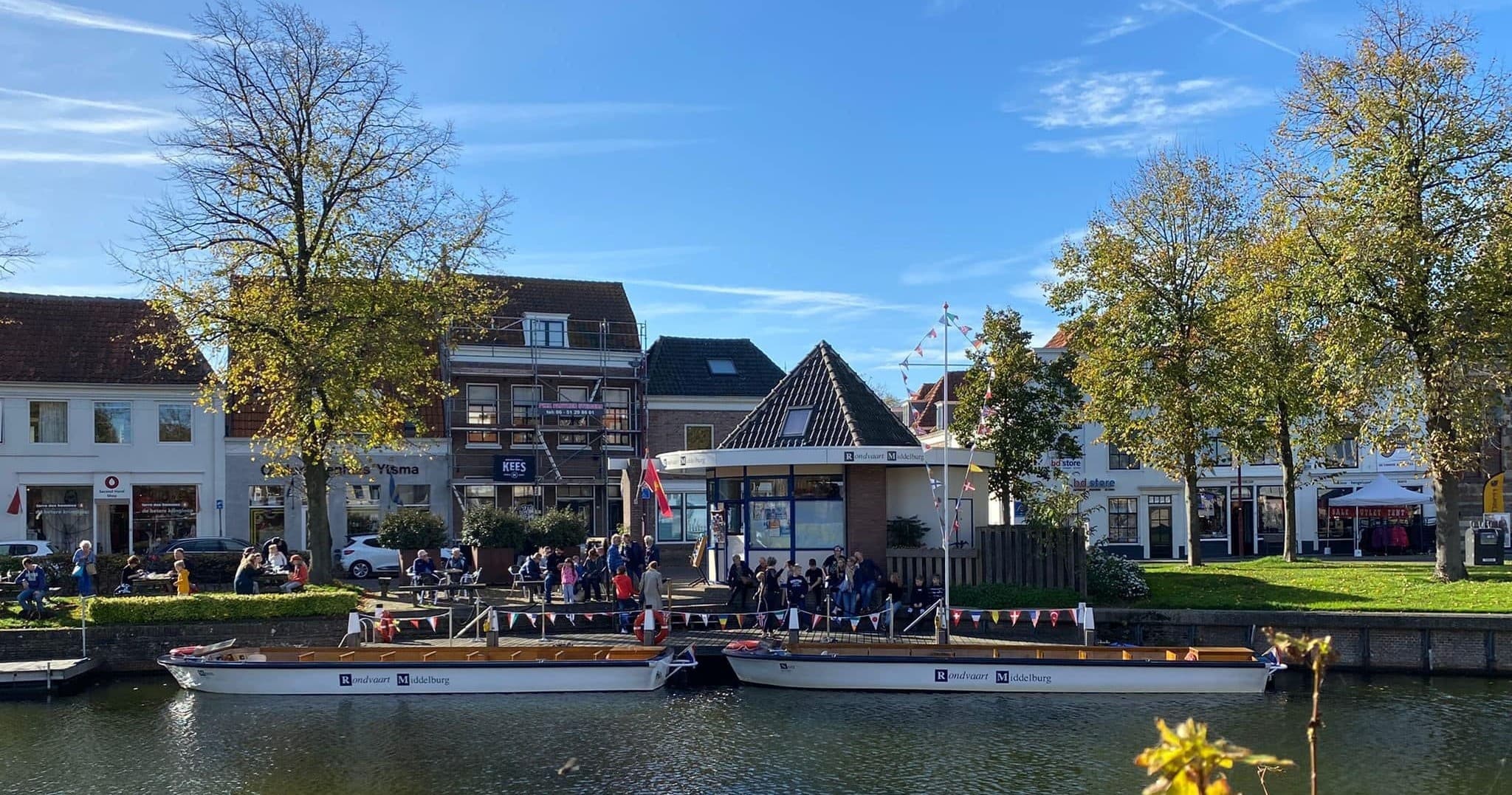 Scenic quay with docked tour boats and waterfront crowd