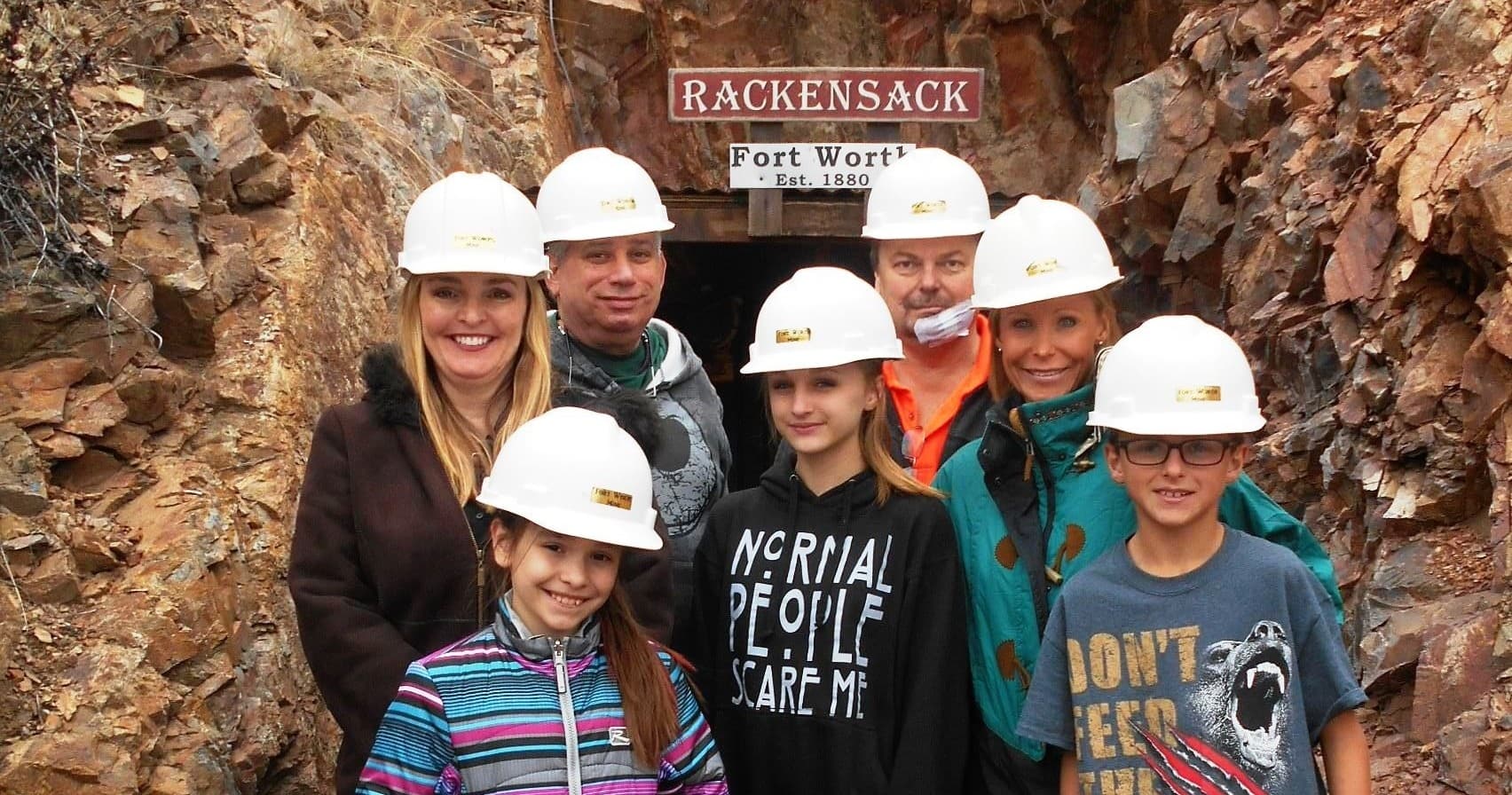Guided mine tour group at Rackensack mine entrance wearing helmets