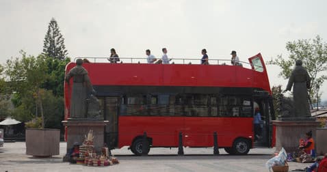 Red open-top sightseeing double-decker bus at Querétaro plaza
