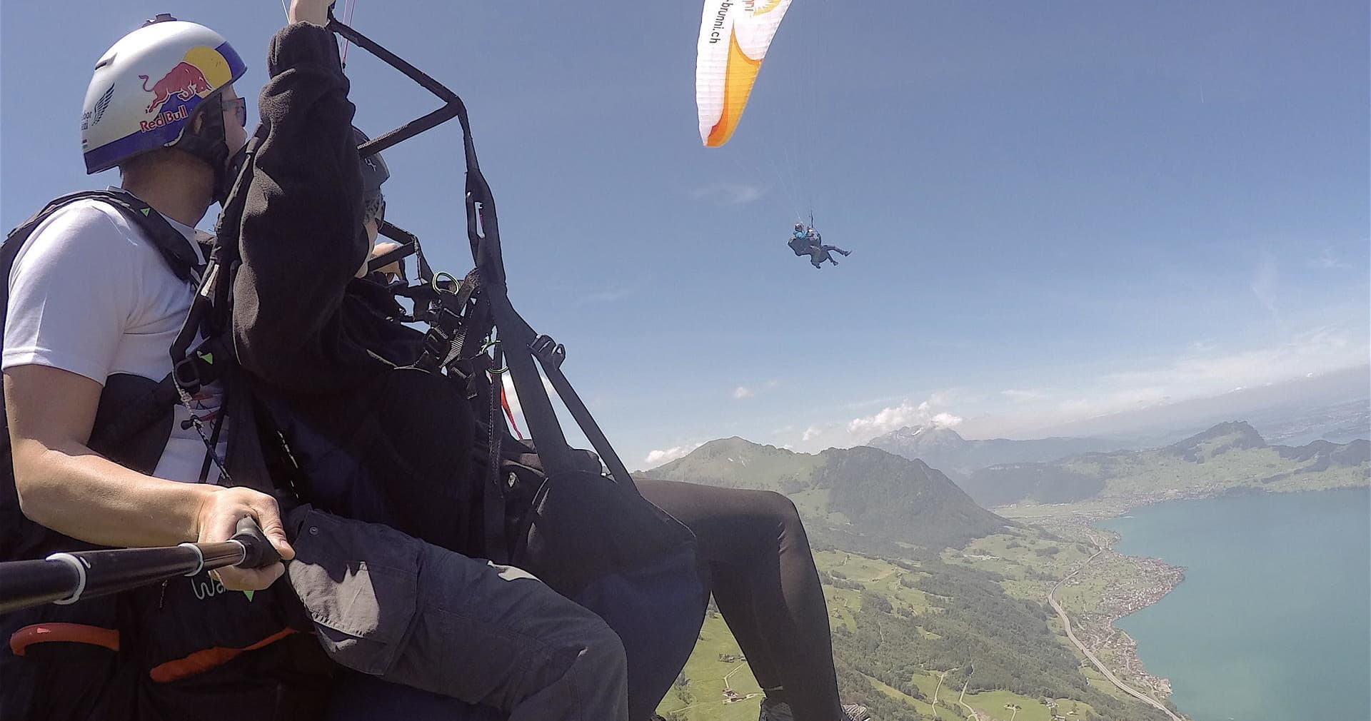 Tandem paragliding along mountain ridge with panoramic vista