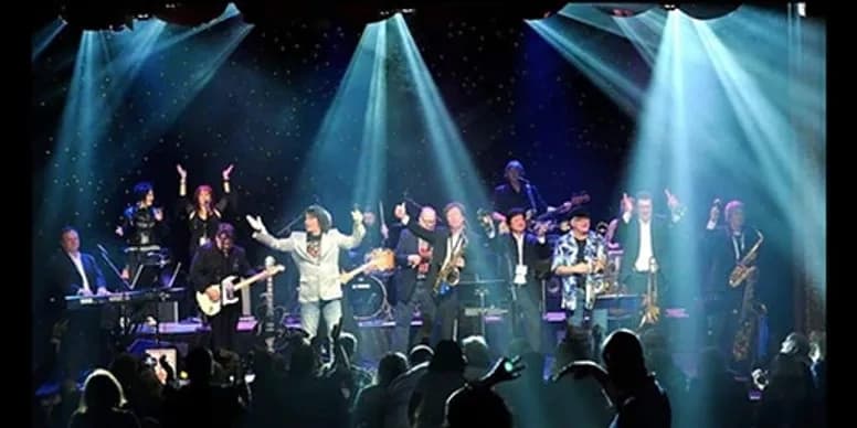 Live band performing onstage with spotlights on an indoor riverboat venue