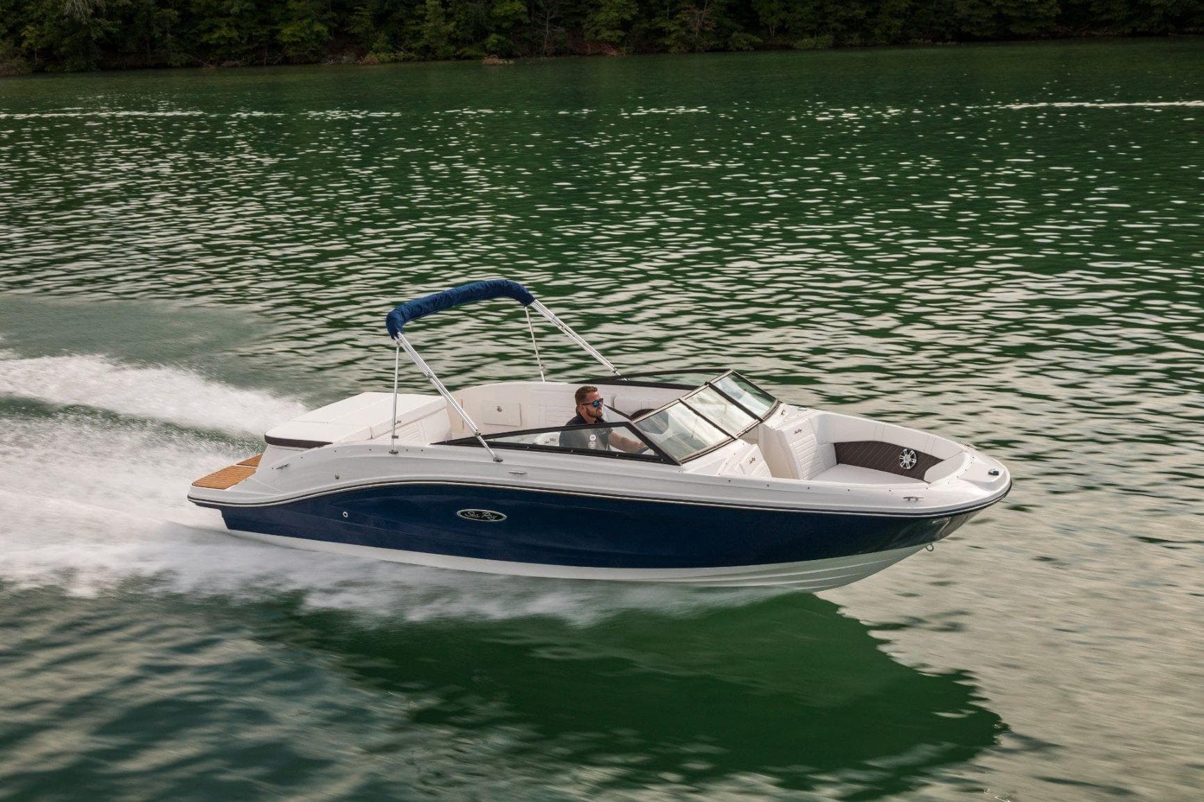 Powerboat cutting through calm lake water for scenic cruise