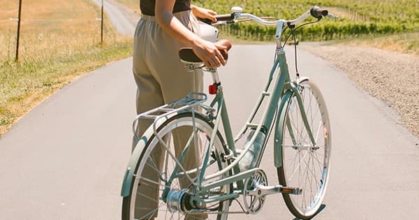 Cyclist with vintage bike on sunny country road in countryside