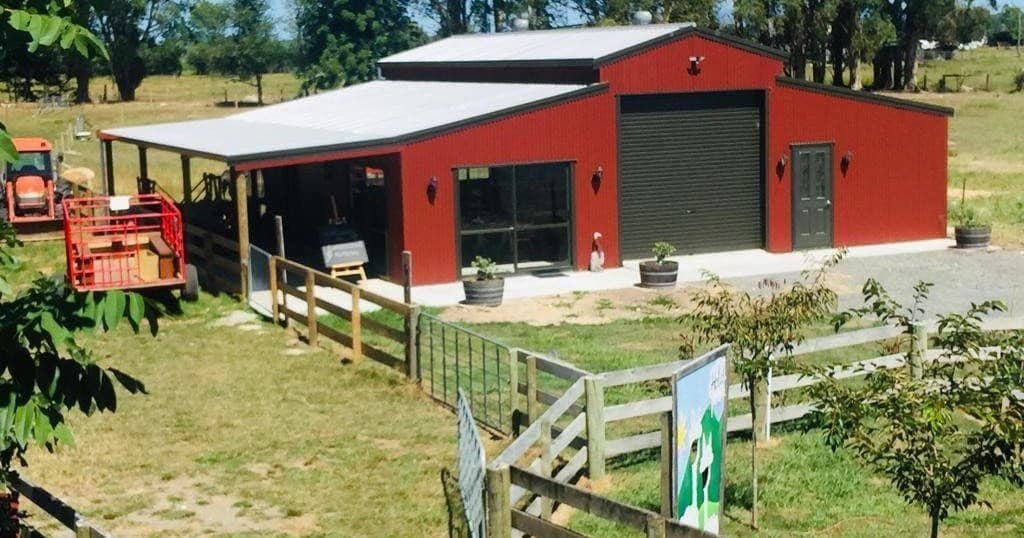 Red farm shed and fenced paddock on rural property
