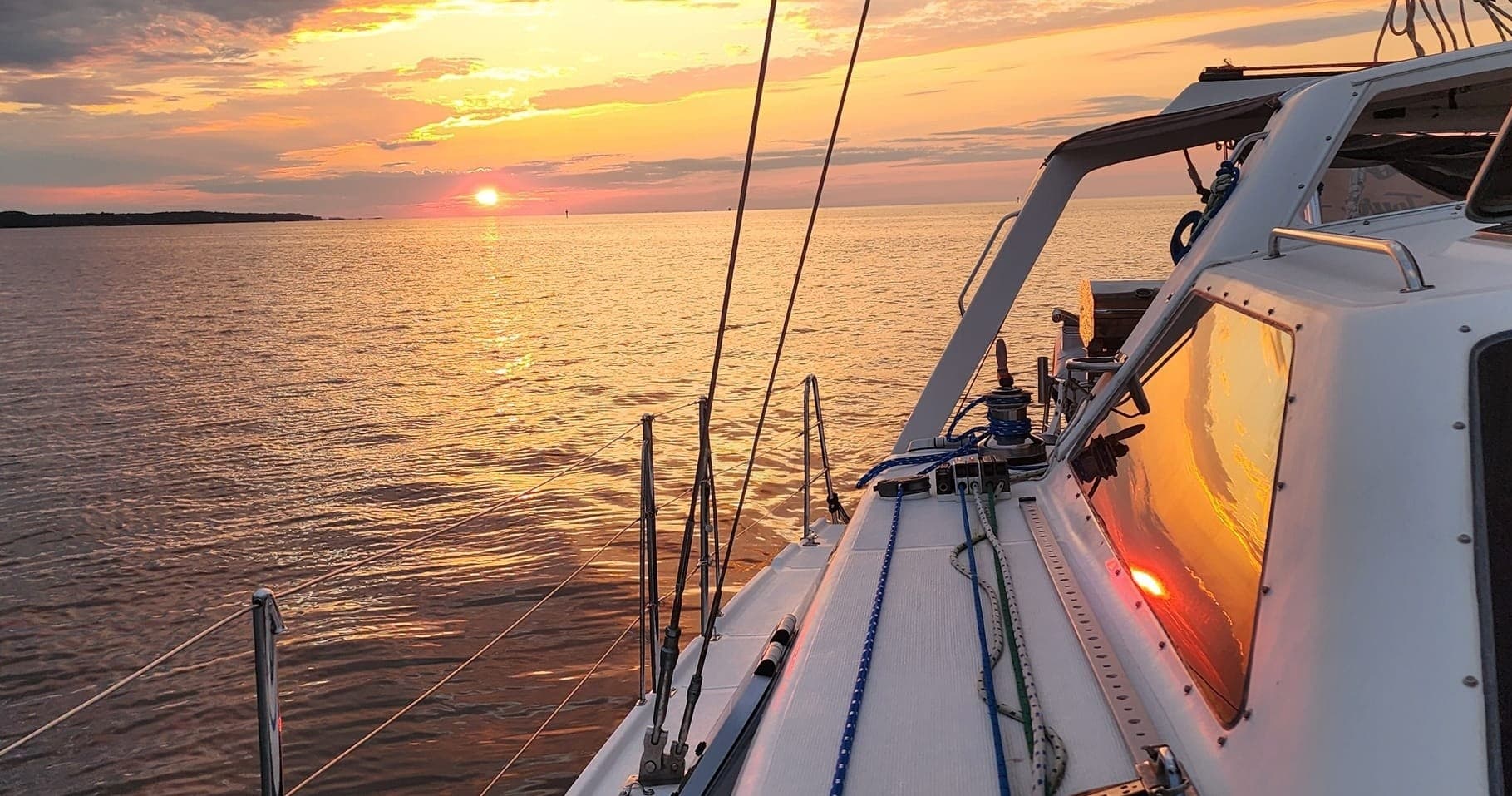 Sailing deck view at sunset over tranquil open water