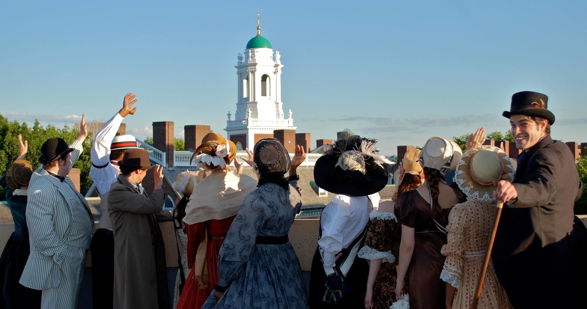 Tour group on Cambridge rooftop with historic church skyline