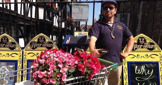 Tour guide with flower cart at riverside market in Canterbury