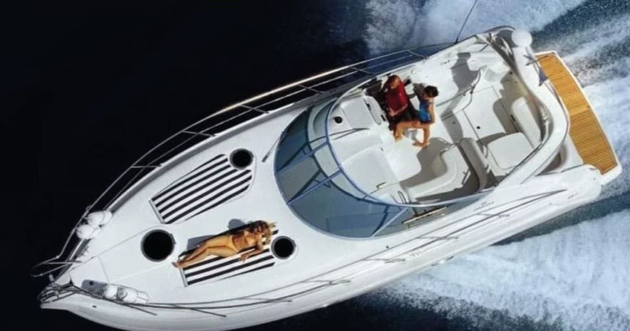 Speedboat cutting through open water with passengers, high-speed ride
