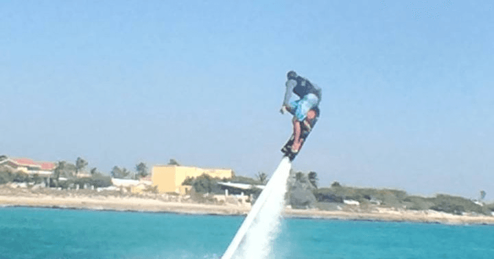 Flyboard rider airborne over clear Caribbean water in Aruba