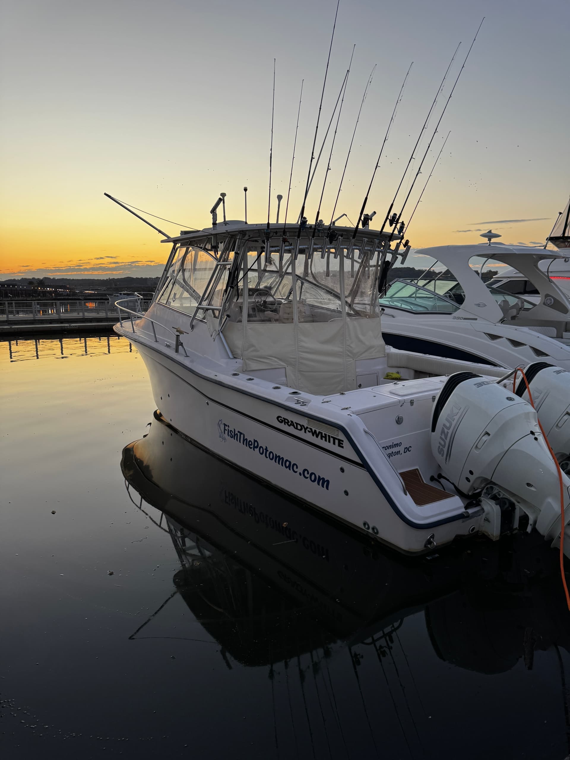 Sportfishing boat moored at marina with fishing rods at dusk