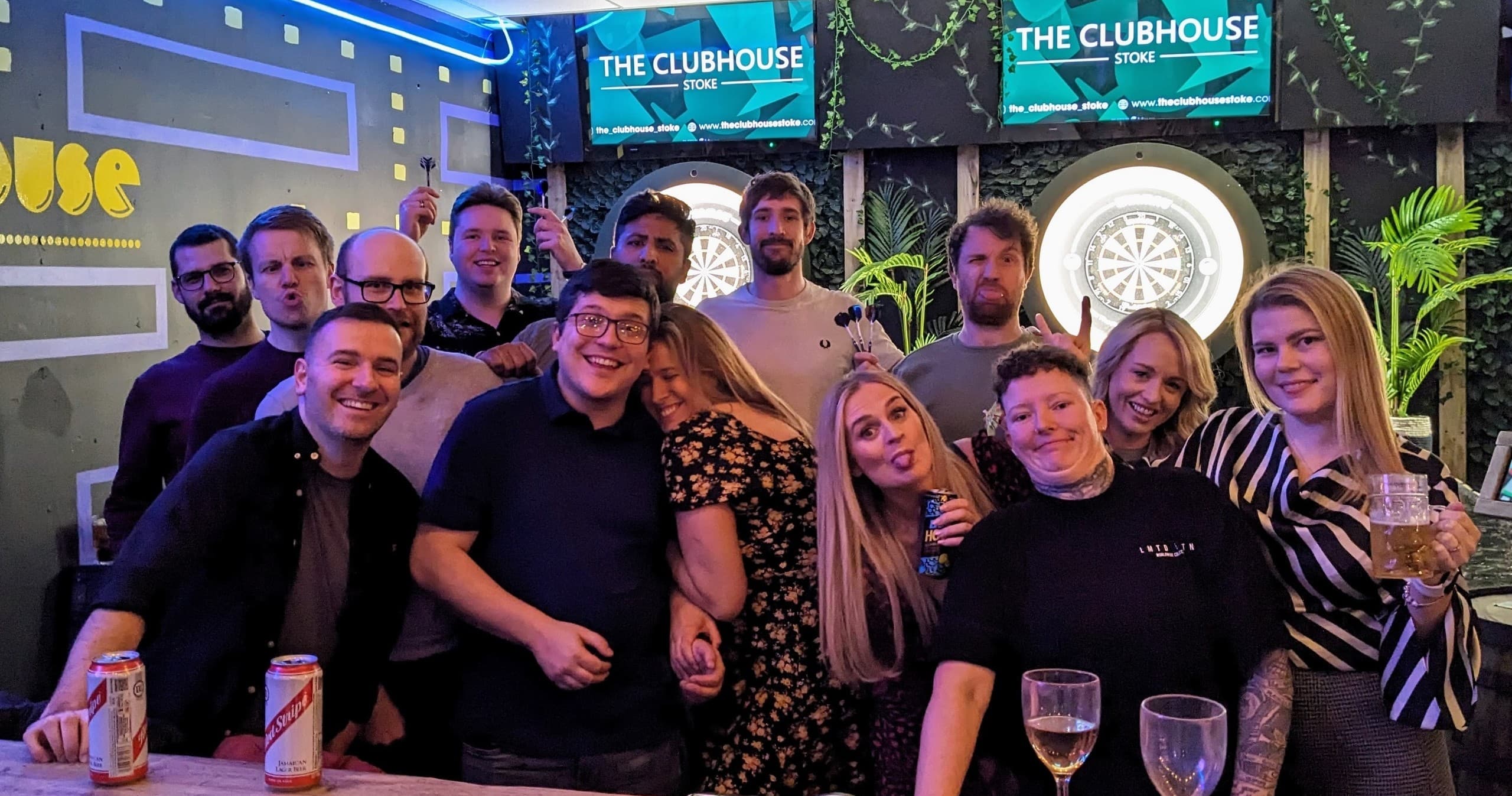 Friends gathered at bar with darts and drinks at The Clubhouse