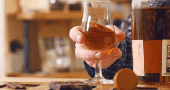 Wine and chocolate pairing in chocolatarium tasting room, glass held
